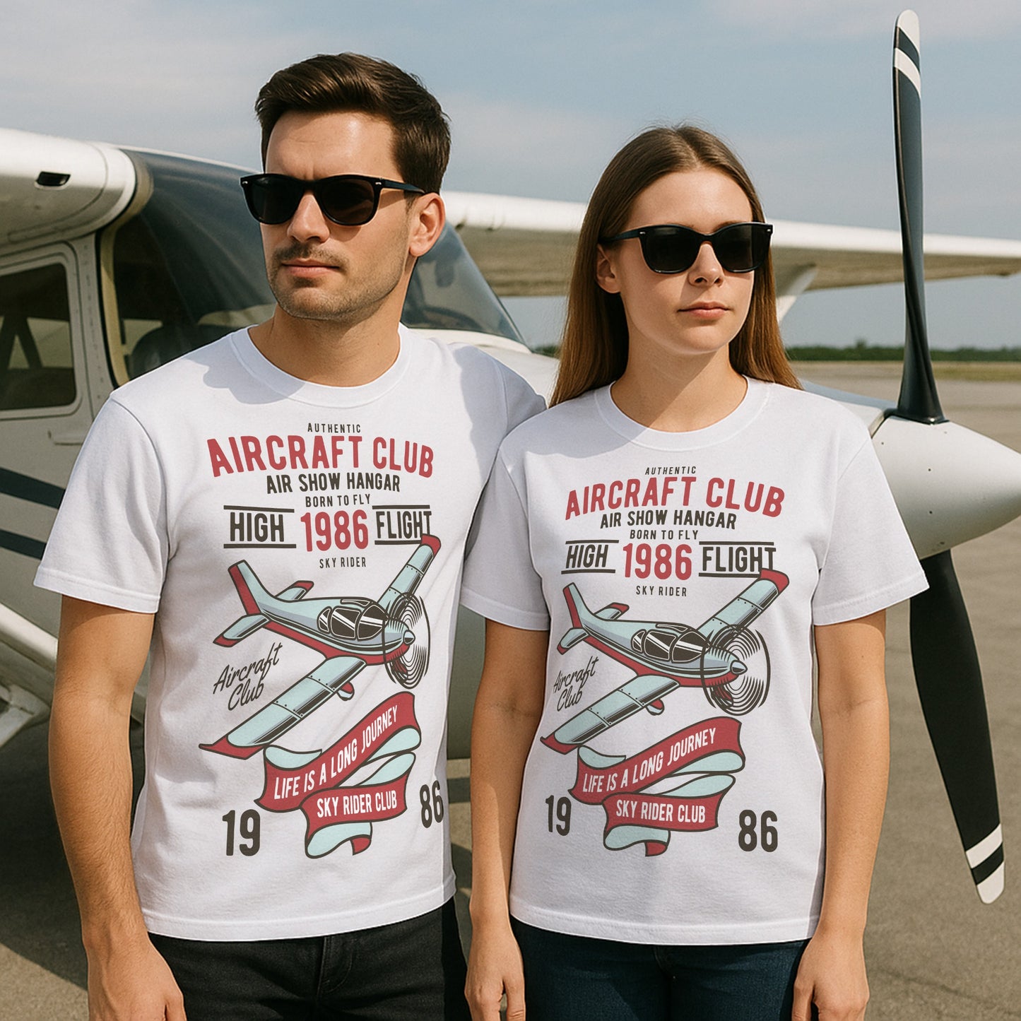 Two people wearing t-shirts with aircraft club design in front of an airplane.