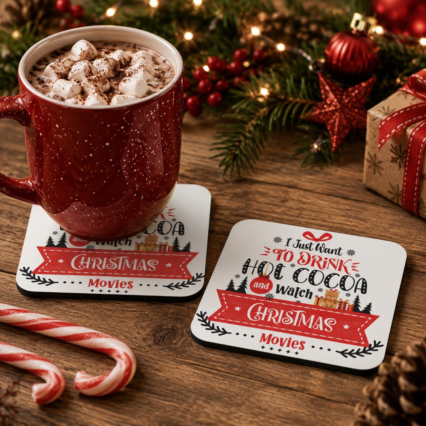 Lifestyle mockup of the I Just Want to Drink Hot Cocoa and Watch Christmas Movies coaster with a festive mug of hot chocolate on one coaster and a second matching coaster displayed beside it on a cosy Christmas table with holiday decorations.
