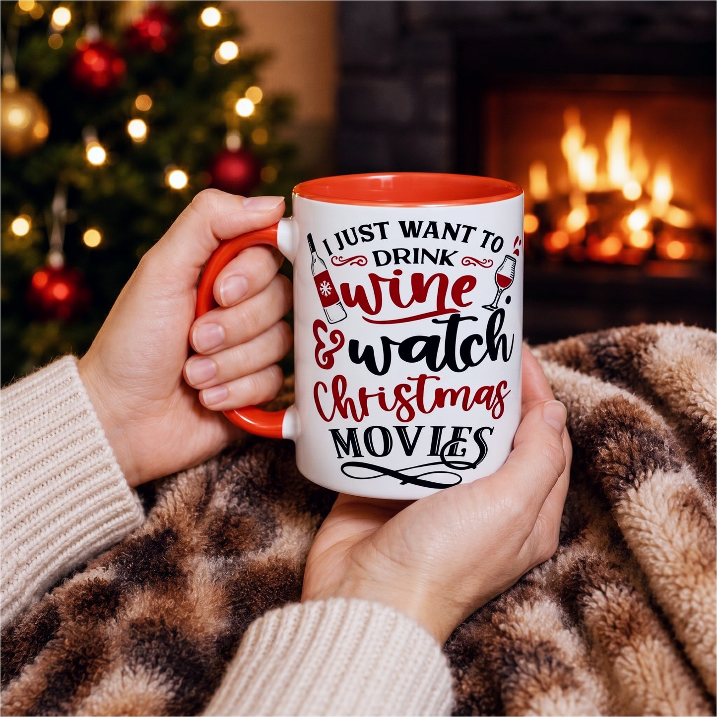 Hands holding an I Just Want To Drink Wine & Watch Christmas Movies mug beside a cosy fireplace and decorated Christmas tree, perfect for festive movie nights, wine lovers, and holiday relaxation.