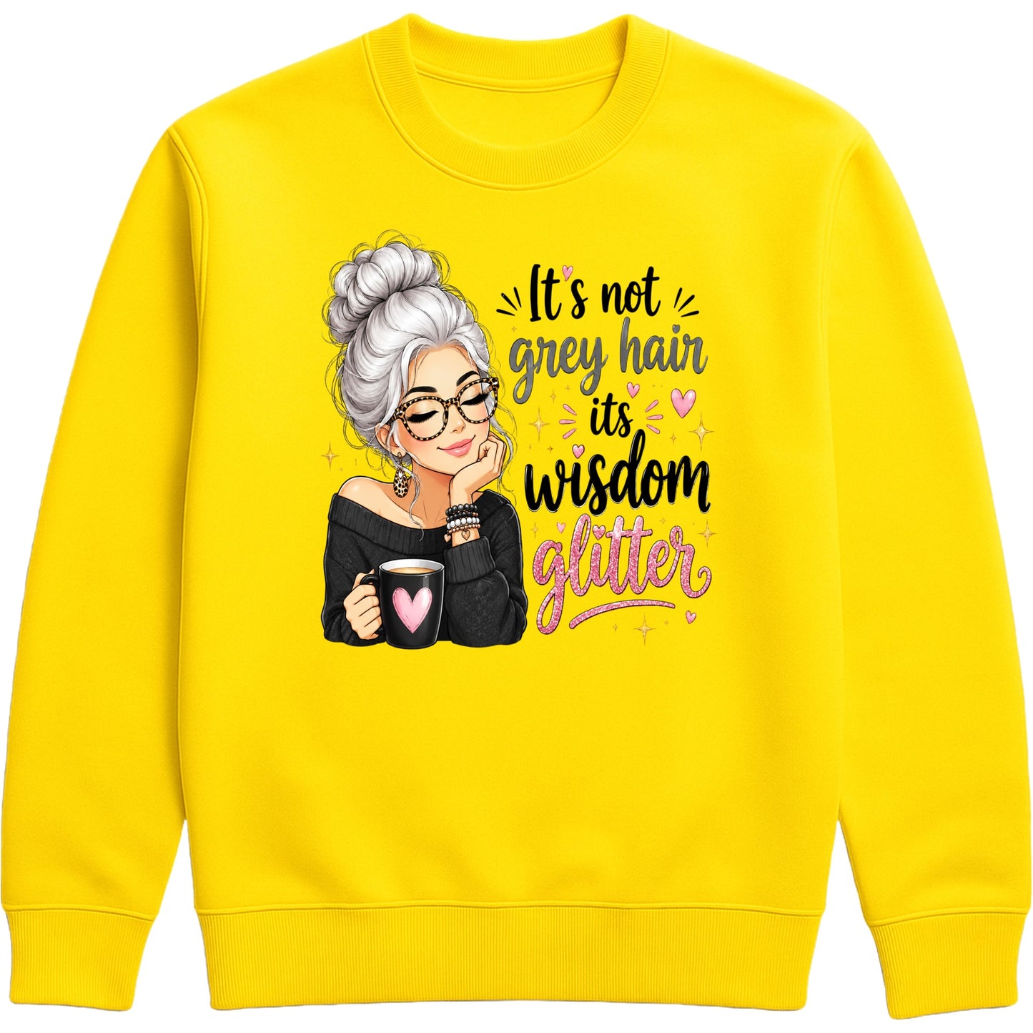 A bright yellow crewneck sweatshirt featuring a graphic of an older woman with grey hair, glasses, and a black top holding a mug, next to the text 'It's not grey hair its wisdom glitter' in black and pink lettering.