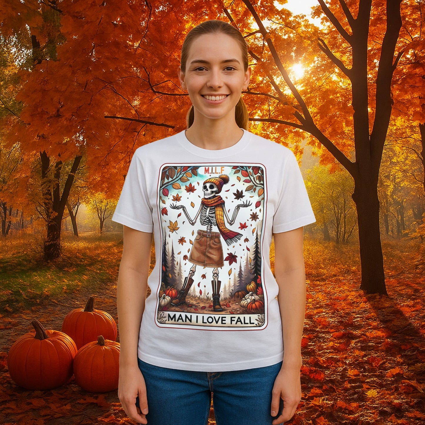 A graphic t-shirt featuring a stylish skeleton in fall attire with the phrase “M.I.L.F. – Man I Love Fall,” surrounded by autumn leaves and pumpkins.