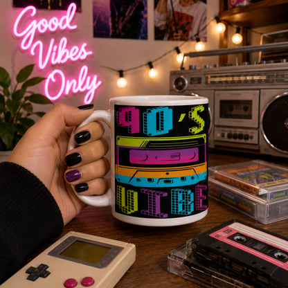 Lifestyle mockup of a colourful 90s Vibe coffee mug with a vibrant retro cassette tape design, held in a retro-inspired room featuring a vintage boombox, cassette tapes, Game Boy, and neon Good Vibes Only sign.