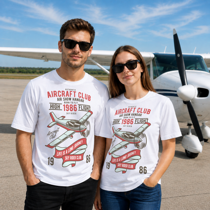 Male and female models wearing the Aircraft Club T-Shirt featuring a vintage propeller aircraft graphic while standing in front of a light aircraft at an airfield. Retro aviation t-shirt for pilots, plane spotters, and aviation enthusiasts.
