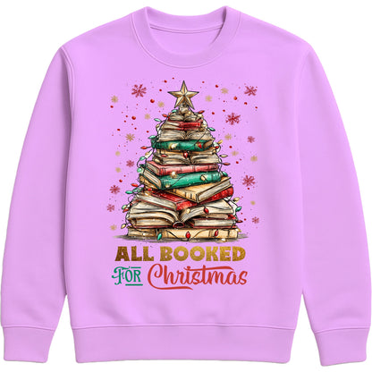 Lavender “All Booked for Christmas” sweatshirt featuring a whimsical book-stack Christmas tree with lights and a star, styled in a cozy holiday aesthetic.