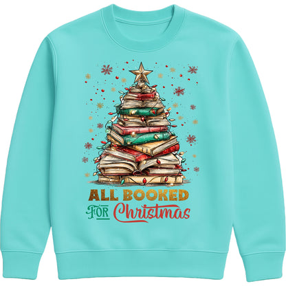 Peppermint “All Booked for Christmas” sweatshirt featuring a whimsical book-stack Christmas tree with lights and a star, styled in a cozy holiday aesthetic.