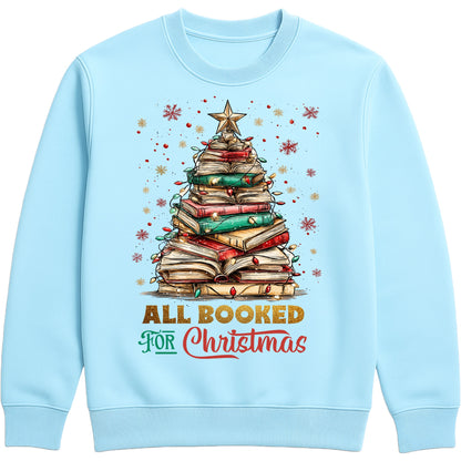 Sky Blue “All Booked for Christmas” sweatshirt featuring a whimsical book-stack Christmas tree with lights and a star, styled in a cozy holiday aesthetic.