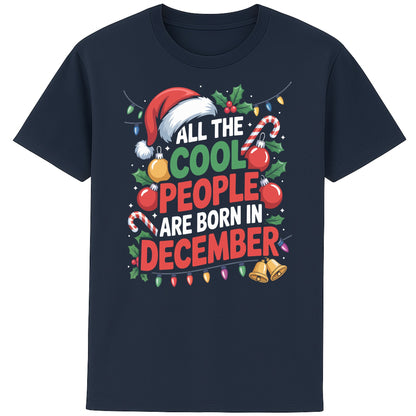 All The Cool People Are Born In December T-Shirt featuring festive Christmas typography with Santa hat, candy canes, holly, baubles, and colourful Christmas lights on a navy unisex tee, perfect funny December birthday shirt and Christmas birthday gift.