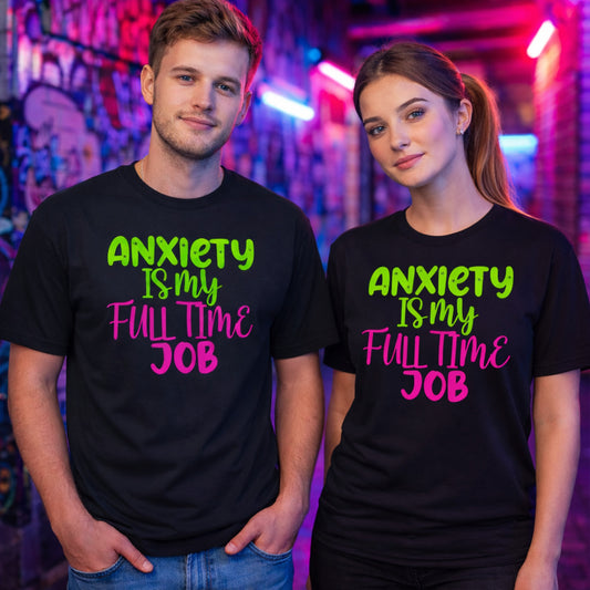 Male and female models wearing the black Anxiety Is My Full Time Job funny anxiety t-shirt with bold neon green and pink typography in a colourful urban streetwear lifestyle setting.