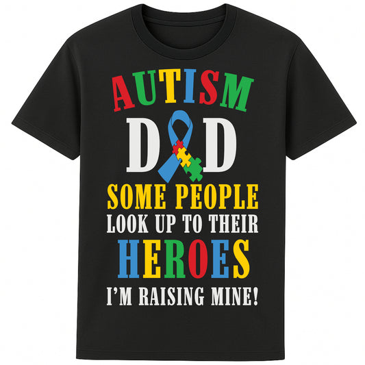 A black t-shirt with bold, colorful text reading: AUTISM DAD SOME PEOPLE LOOK UP TO THEIR HEROES I'M RAISING MINE," The design celebrates fatherhood and pride in raising a child with autism.