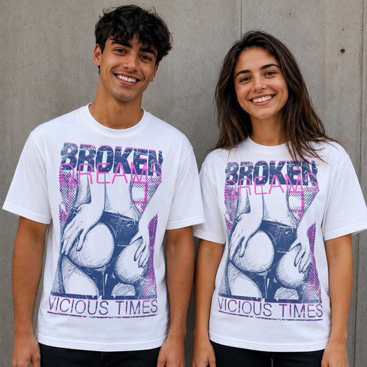 Male and female models wearing white Broken Dreams Vicious Times graphic T-shirts featuring distressed pink and navy artwork with a bold grunge streetwear design.
