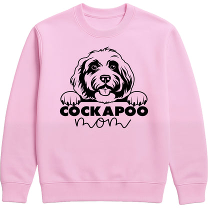 Pink sweatshirt with "Cockapoo Mom" text and a cute Cockapoo face graphic, perfect for dog moms and pet lovers.