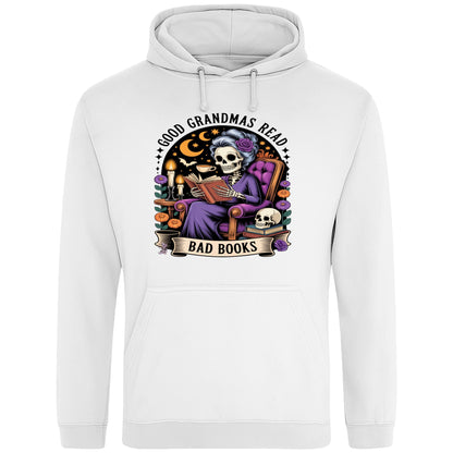White Good Grandmas Read Bad Books Hoodie featuring a spooky cute skeleton grandma reading in a cosy armchair with candles and flowers, funny grandma hoodie for book lovers and gothic readers.
