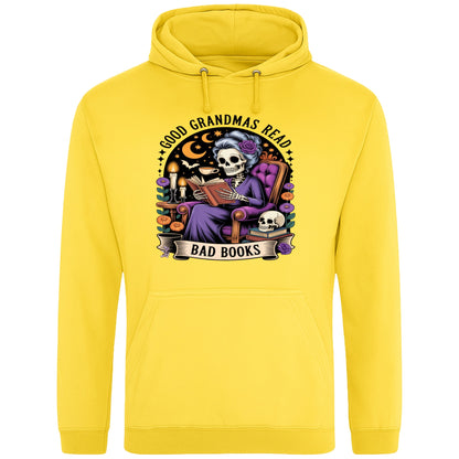 Yellow Good Grandmas Read Bad Books Hoodie featuring a spooky cute skeleton grandma reading in a cosy armchair with candles and flowers, funny grandma hoodie for book lovers and gothic readers.