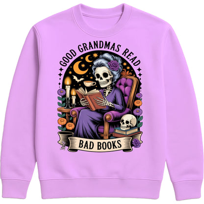 Lavender Good Grandmas Read Bad Books Sweatshirt featuring a spooky cute skeleton grandma reading in a cosy armchair with candles, flowers, and moon details, funny grandma sweatshirt for book lovers and gothic book lovers.
