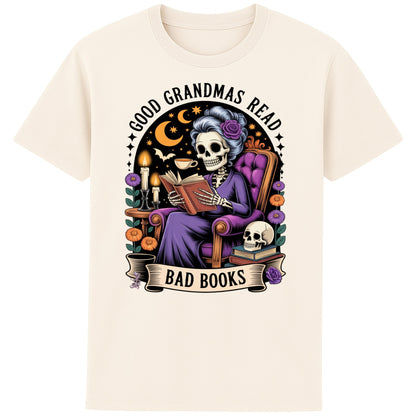 Naturel colour Good Grandmas Read Bad Books T-Shirt featuring a spooky cute skeleton grandma reading in a cosy armchair with candles and flowers, funny grandma t shirt for book lovers and gothic book lovers.