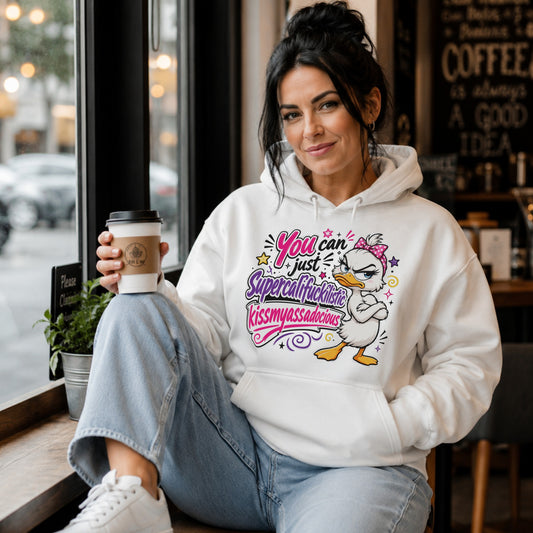 Woman wearing a white Grumpy Sarcastic Duck Hoodie featuring a colourful funny duck graphic while relaxing with a takeaway coffee in a modern coffee shop, unisex novelty graphic hoodie.