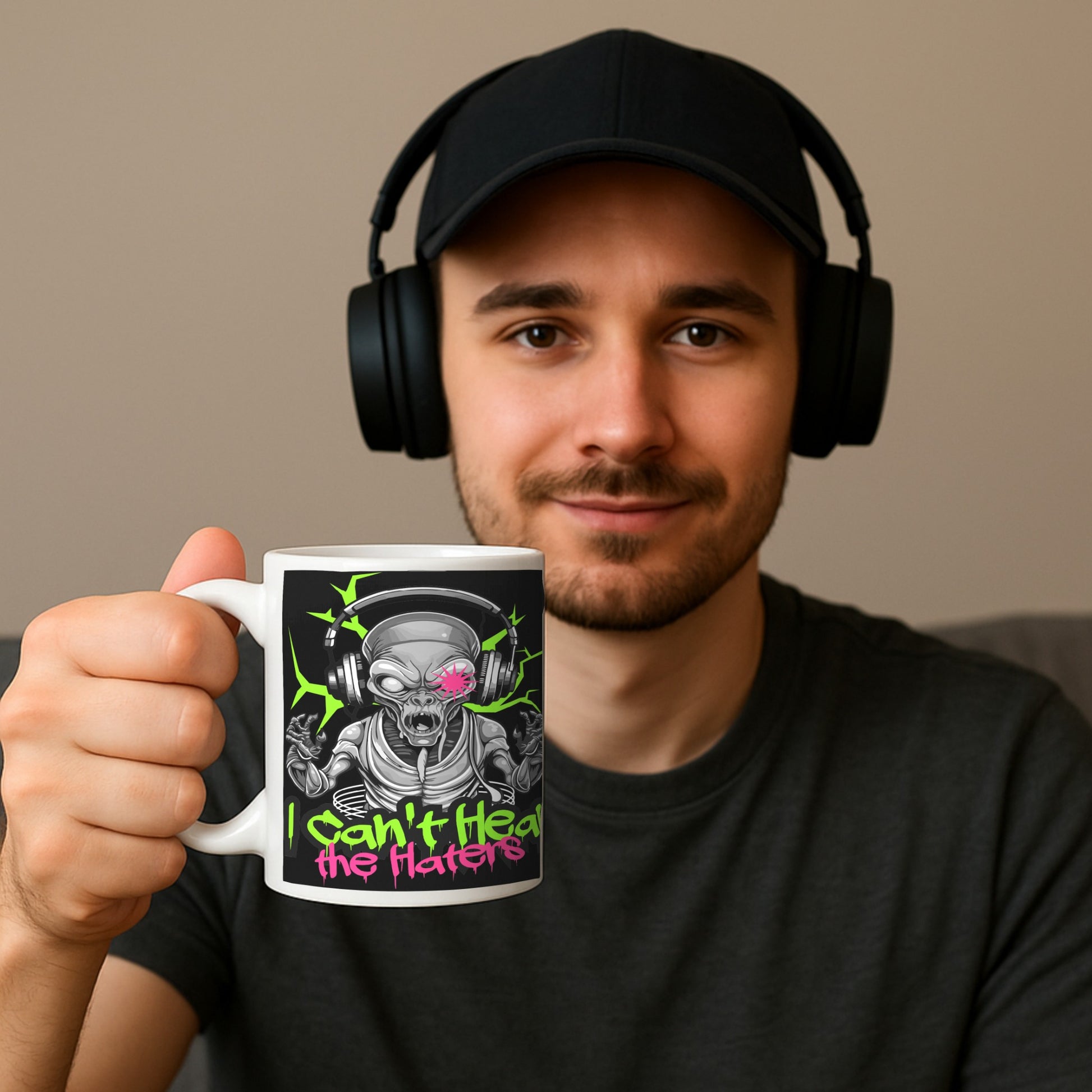 Man wearing headphones holding a I Can’t Hear the Haters” coffee mug mock up  featuring a neon alien wearing headphones and bold graffiti-style text