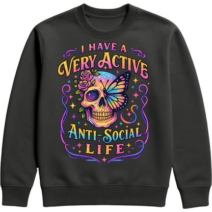 I Have A Very Active Anti Social Life sweatshirt featuring a colourful neon sugar skull, butterfly, and floral graphic on a black unisex graphic sweatshirt, perfect for introverts who love sarcastic humour, alternative fashion, and cosy everyday style.