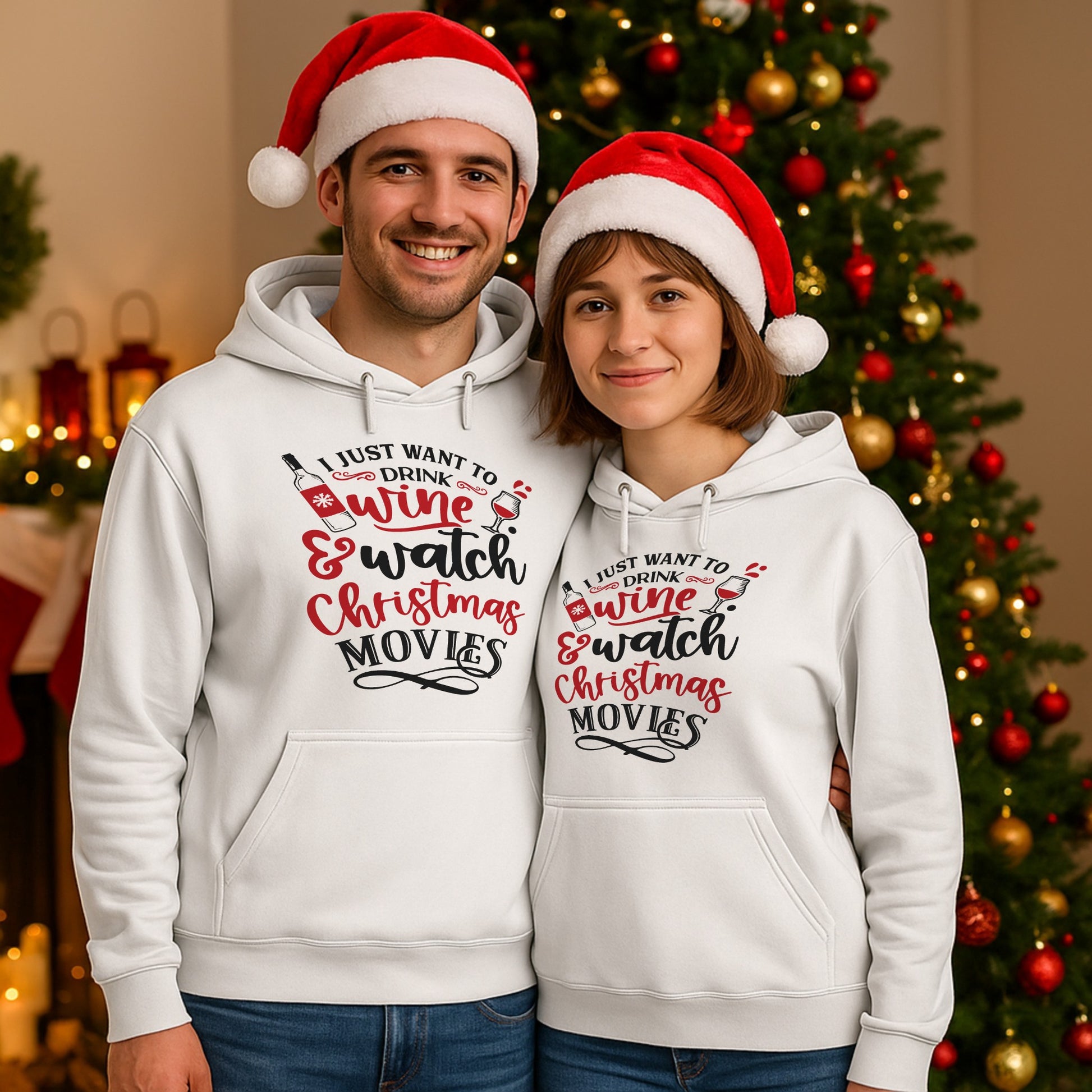 Smiling couple wearing matching I Just Want To Drink Wine & Watch Christmas Movies hoodies in front of a decorated Christmas tree, perfect for festive movie nights, cosy holiday evenings, and wine lovers.