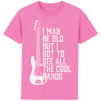 An bubble pink colour unisex t-shirt featuring distressed text "I May Be Old But I Saw All the Cool Bands" with a vintage electric bass guitar graphic, perfect for music lovers and retro style fans