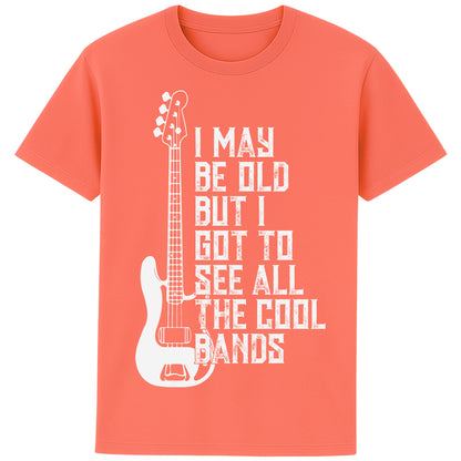 A fiesta colour unisex t-shirt featuring distressed text "I May Be Old But I Saw All the Cool Bands" with a vintage electric bass guitar graphic, perfect for music lovers and retro style fans