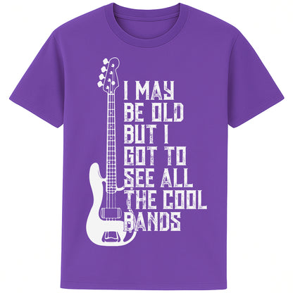 A purple colour unisex t-shirt featuring distressed text "I May Be Old But I Saw All the Cool Bands" with a vintage electric bass guitar graphic, perfect for music lovers and retro style fans