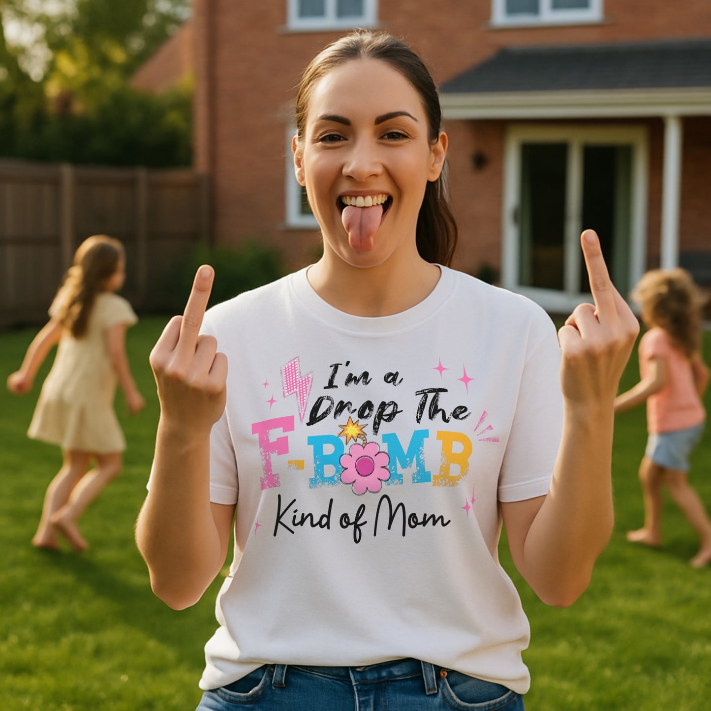 "A woman wearing a white t-shirt with colorful text reading ‘I’m a Drop the F-Bomb Kind of Mom’ with sparkles, lightning bolts, and flower graphic."