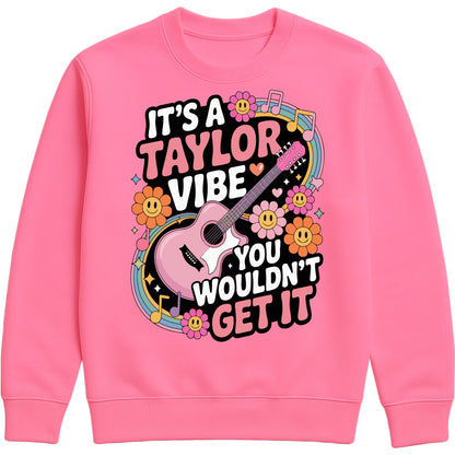 Cosy candyfloss pink colour It's A Taylor Vibe You Wouldn't Get It retro music fan sweatshirt in pink featuring a colourful guitar, flowers, rainbow accents, musical notes, and playful typography for pop music lovers and concert fans.