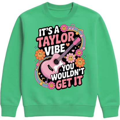 Cosy kelly green colour It's A Taylor Vibe You Wouldn't Get It retro music fan sweatshirt in pink featuring a colourful guitar, flowers, rainbow accents, musical notes, and playful typography for pop music lovers and concert fans.