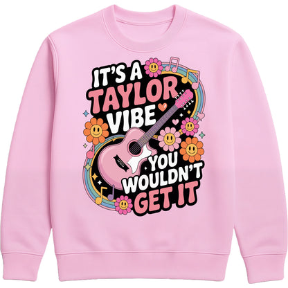 Cosy pink It's A Taylor Vibe You Wouldn't Get It retro music fan sweatshirt in pink featuring a colourful guitar, flowers, rainbow accents, musical notes, and playful typography for pop music lovers and concert fans.