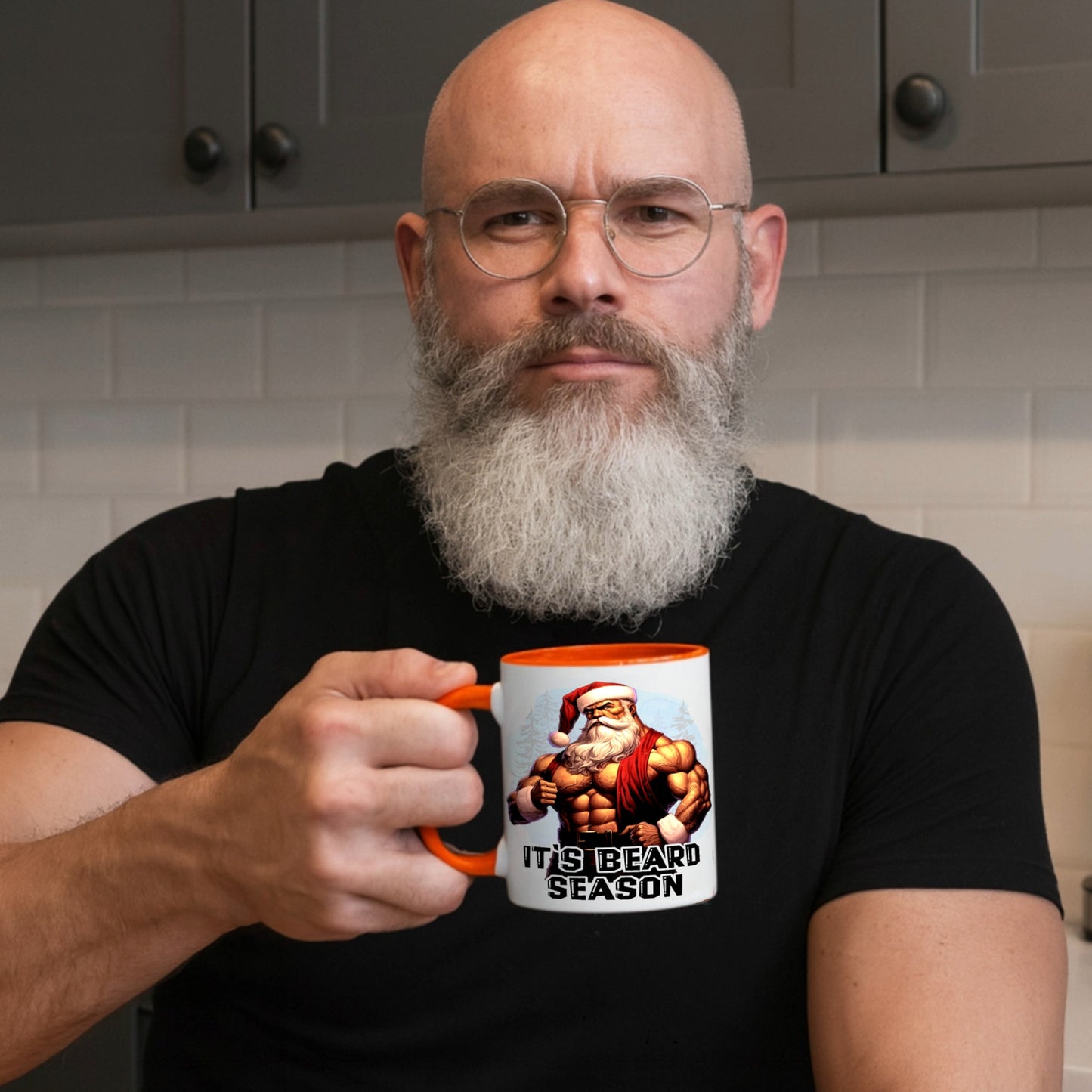 Bearded man holding the It's Beard Season coffee mug featuring a ripped Santa design in a modern kitchen, showcasing a funny Christmas mug for beard lovers, dads, gym fans, and Secret Santa gifts.