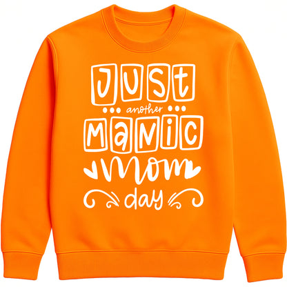 A orange sweatshirt with 'Just Another Manic Mom Day' printed on the front, styled for casual everyday wear, perfect for moms balancing busy lives.