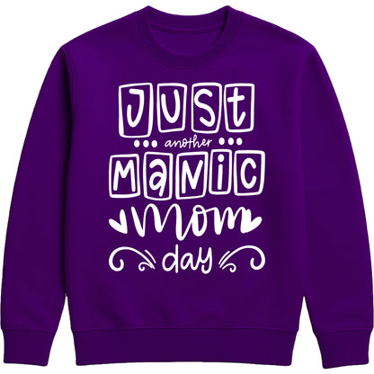 A purple sweatshirt with 'Just Another Manic Mom Day' printed on the front, styled for casual everyday wear, perfect for moms balancing busy lives.