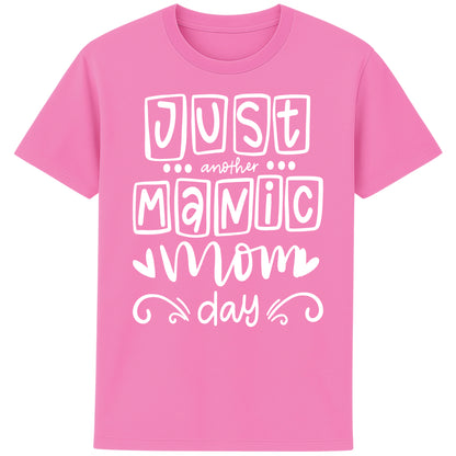 A bubble pink colour t-shirt featuring the bold, playful phrase “Just Another Manic Mom Day” across the front in white lettering. The shirt is styled casually, perfect for everyday mom life, offering a comfortable fit ideal for running errands, school drop-offs, or relaxing at home. 