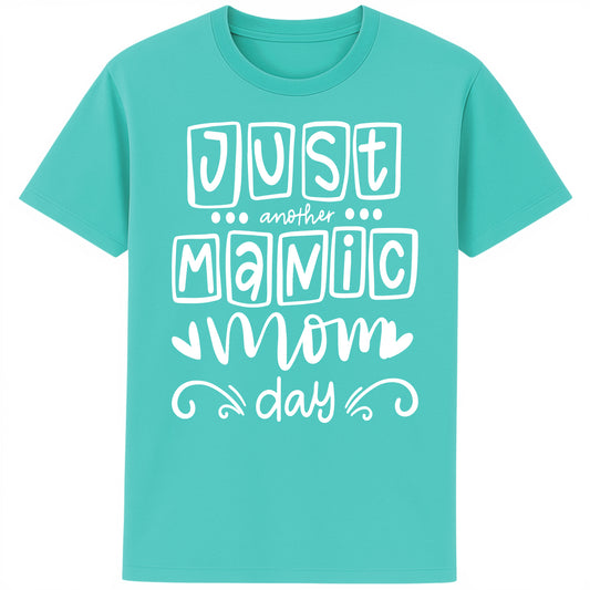 A bright pool blue t-shirt featuring the bold, playful phrase “Just Another Manic Mom Day” across the front in white lettering. The shirt is styled casually, perfect for everyday mom life, offering a comfortable fit ideal for running errands, school drop-offs, or relaxing at home. 