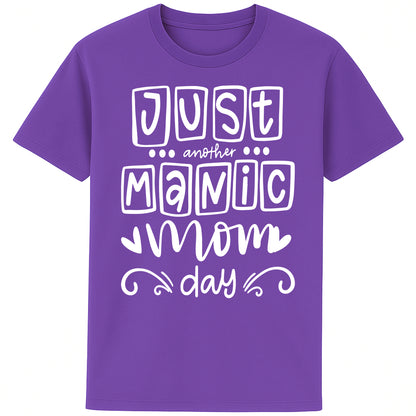A purple t-shirt featuring the bold, playful phrase “Just Another Manic Mom Day” across the front in white lettering. The shirt is styled casually, perfect for everyday mom life, offering a comfortable fit ideal for running errands, school drop-offs, or relaxing at home. 