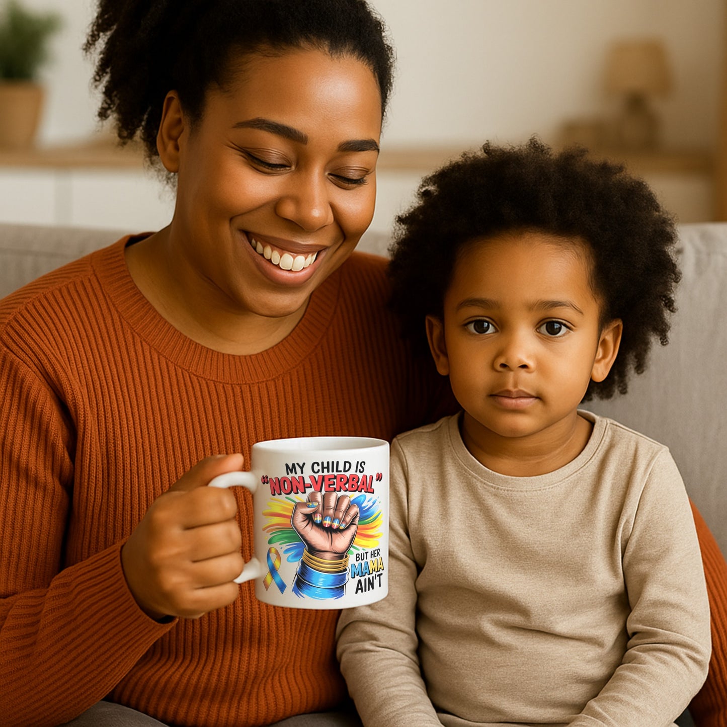 Woman with a child holding a mug with autism awareness design reading ‘My Child is Non-Verbal But Her Mama Ain’t,’ featuring a colourful raised fist and awareness ribbon.”