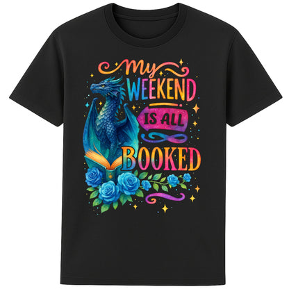 My Weekend Is All Booked book lover t-shirt featuring a blue fantasy dragon reading an enchanted book surrounded by roses and colourful bookish artwork on a black t-shirt.
