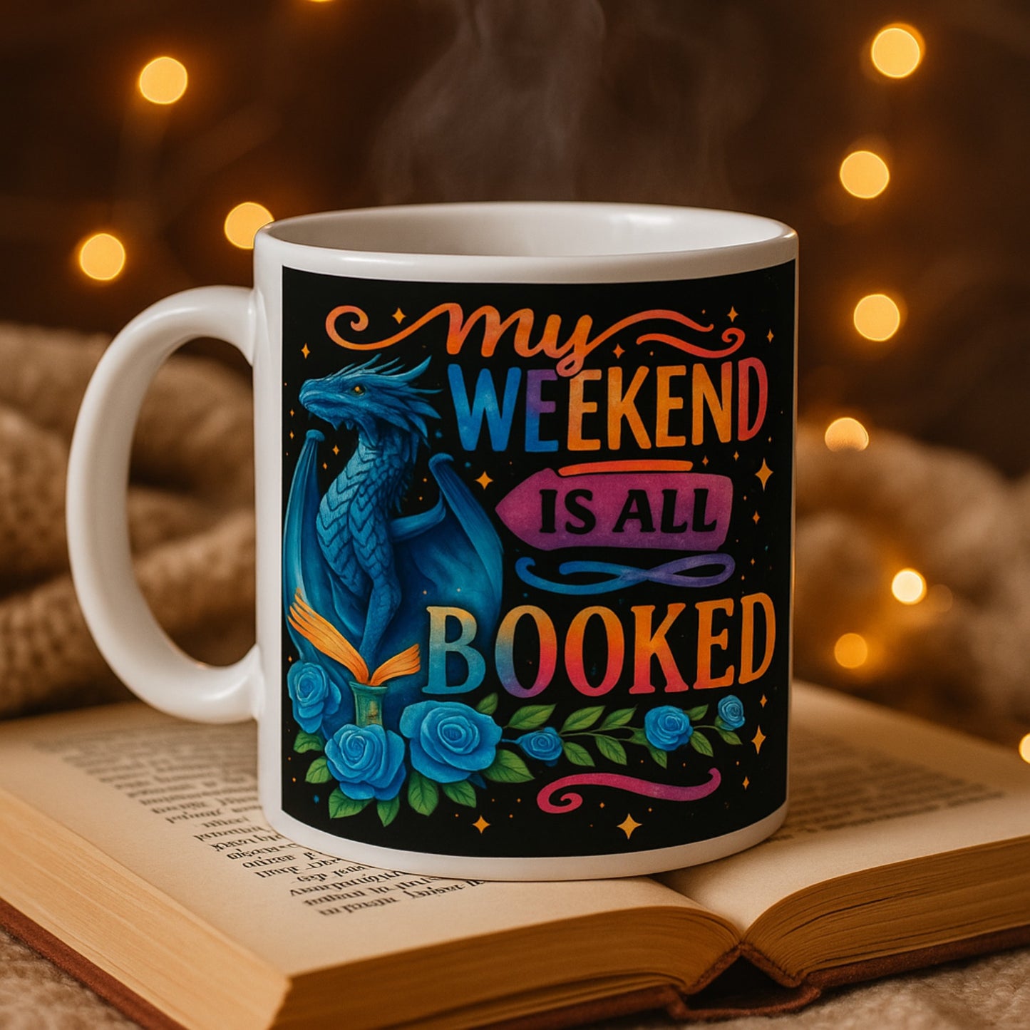Mug with dragon design and 'My weekend is all booked' text on an open book with warm lighting.