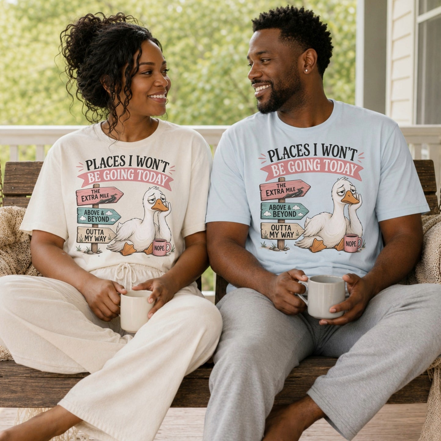 Couple relaxing on a porch wearing Places I Won't Be Going Today funny sarcastic goose T-shirts featuring a grumpy goose with a "Nope" coffee mug and humorous signposts.