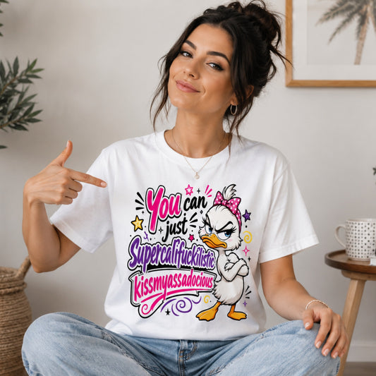 Female model wearing a white sarcastic grumpy duck T-shirt with the funny quote "You Can Just Supercalifuckilistic Kissmyassadocious", styled with relaxed fit jeans and white trainers in a bright lifestyle setting.