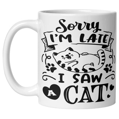 White coffee mug featuring a cartoon cat with paw prints and hearts alongside the phrase "Sorry I'm Late, I Saw A Cat", a funny cat lover mug for cat owners and pet parents.