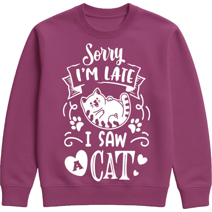 A plum colour sweatshirt with white text and a charming design on the front. It reads: "Sorry I'm late I saw a cat" accompanied by a cartoon cat illustration, paw prints, and whimsical accents. Perfect for cat lovers and those who embrace their feline-induced tardiness with humour.