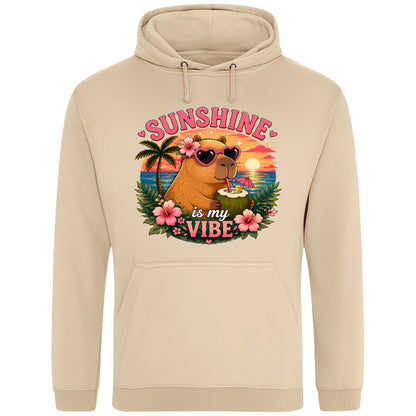 Nude colour Sunshine Is My Vibe Capybara Hoodie featuring a tropical beach graphic with a relaxed capybara, palm trees, hibiscus flowers and a colourful summer sunset.