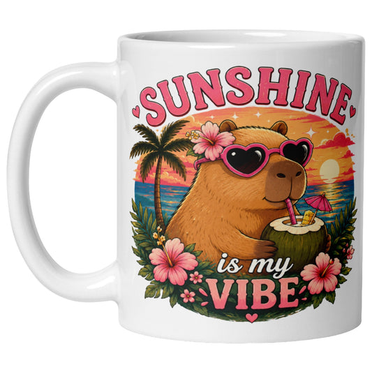 Sunshine Is My Vibe Capybara Mug featuring a cute capybara wearing heart-shaped sunglasses, relaxing with a coconut drink on a tropical beach at sunset.