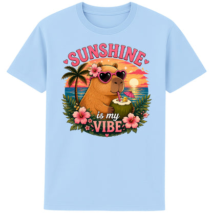 Blue Soul colour Sunshine Is My Vibe Capybara T-Shirt featuring a cute capybara wearing heart-shaped sunglasses, holding a coconut drink with tropical flowers, palm trees and a colourful summer beach sunset graphic.