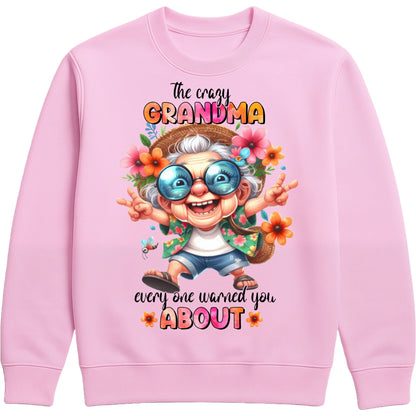 Pink funny grandma sweatshirt featuring a colourful cartoon grandma wearing sunglasses with the phrase "The Crazy Grandma Everyone Warned You About", perfect gift for grandma, grandmother birthday gift, Grandparents Day gift, and gift from grandkids.