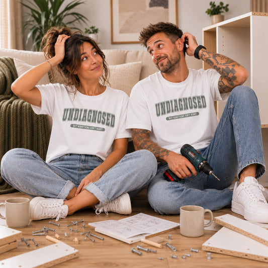 Man and woman wearing matching Undiagnosed But Something Ain't Right funny slogan T-shirts while assembling flat-pack furniture in a bright modern home.