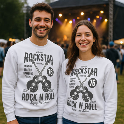 Two people wearing matching white vintage rockstar sweatshirt with bold retro guitar graphic and tour-inspired design, at an outdoor event.
